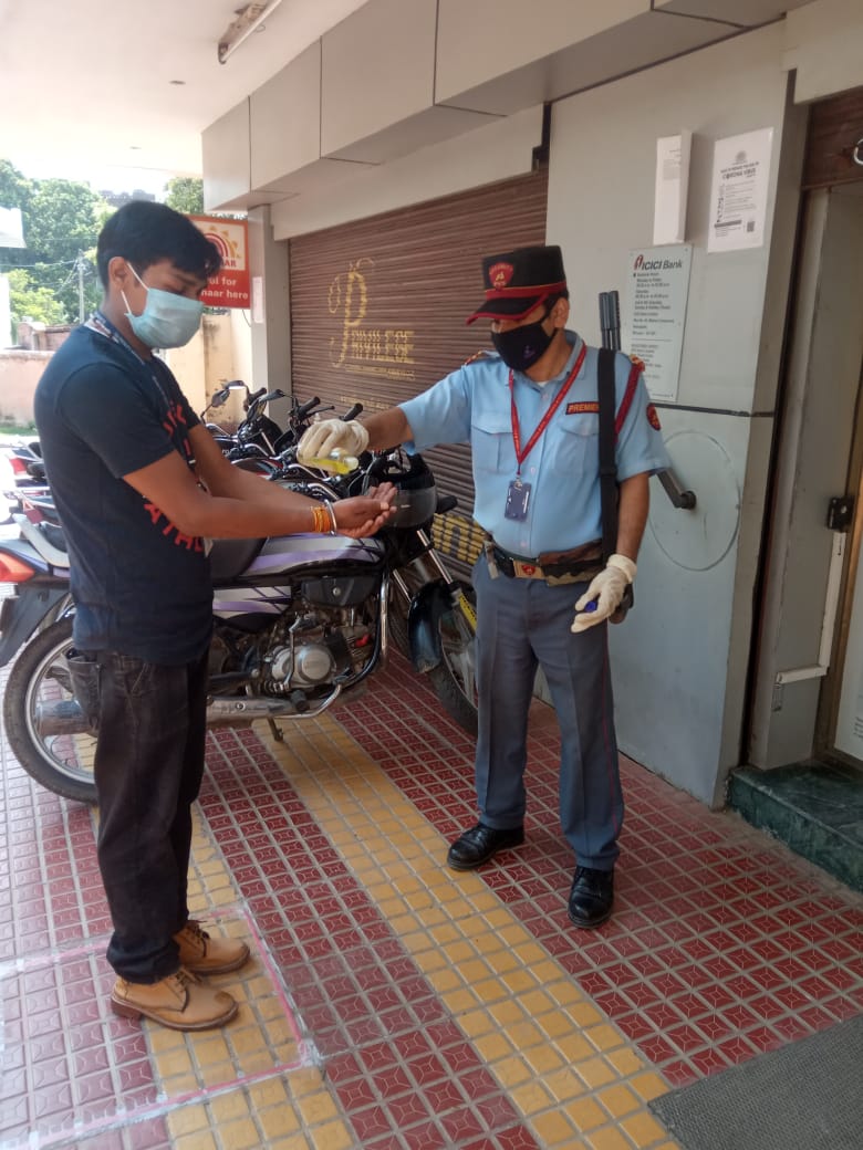 sanitizing the hands by a pvs security personnel during covid