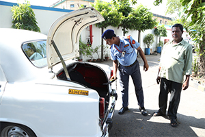 security personnel of pvs checking a car using a metal detector.