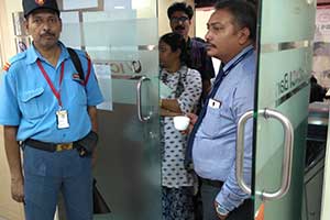security guard of pvs security service, outside an ATM counter